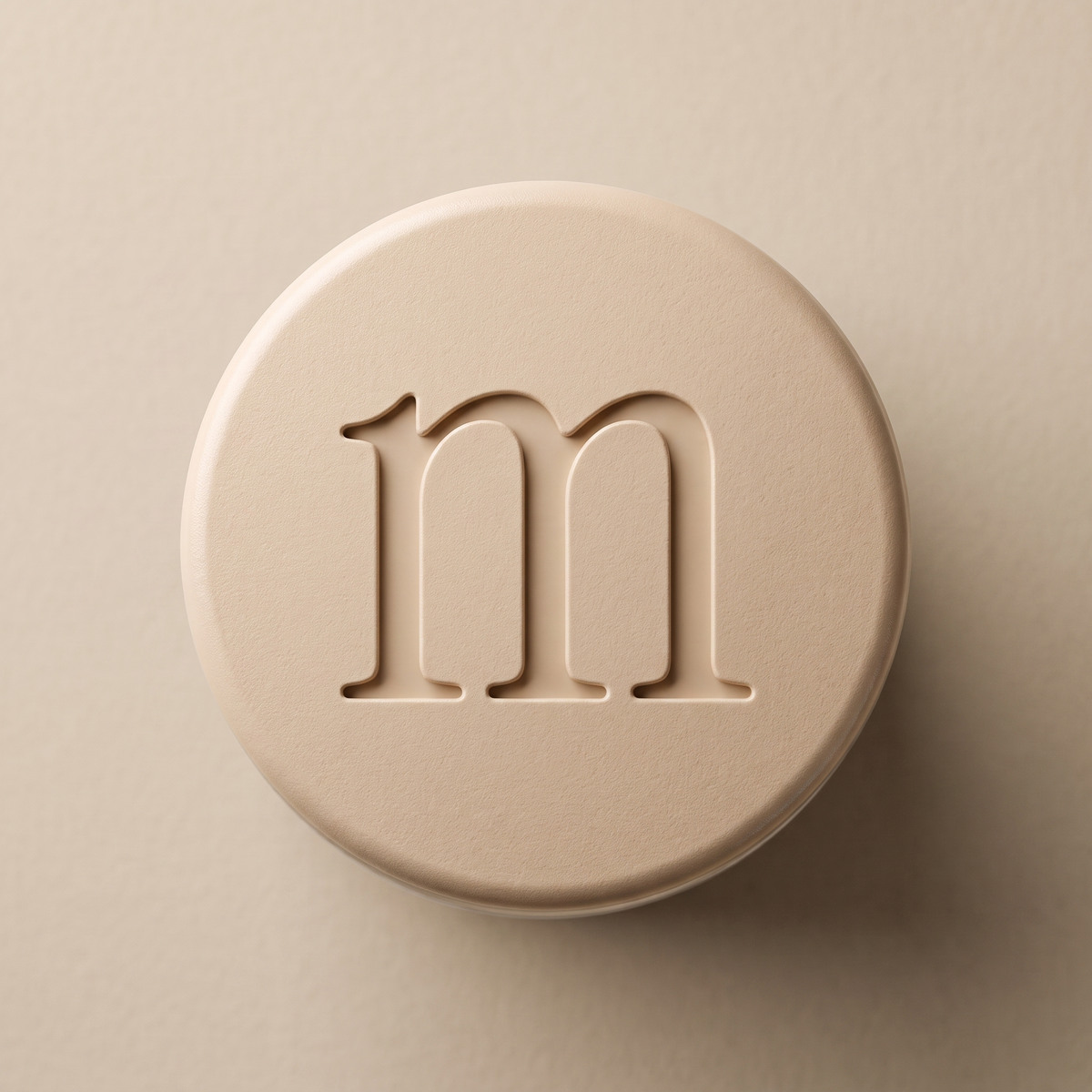 The m pressed into the cap